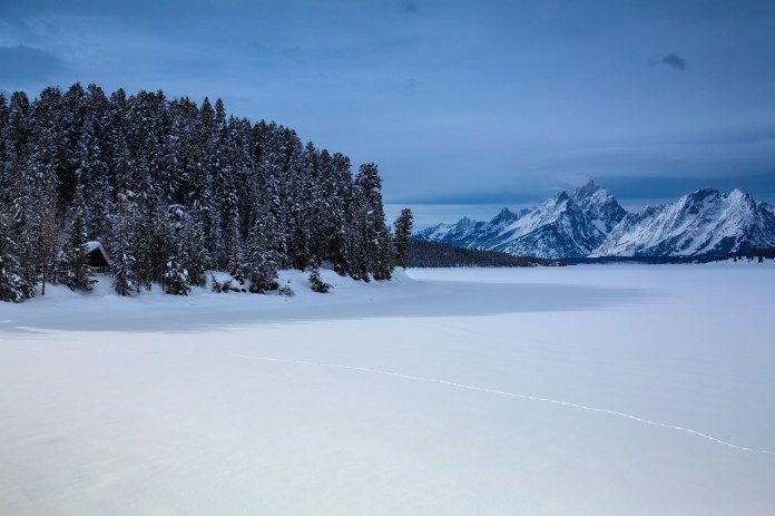 Snow covered Tetons form a frozen Jackson Lake in Grand Teton National Park, WY