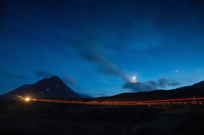 Moon and stars as cars passing on A82 near the River Etive