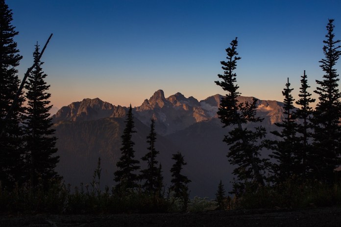 sunrise over the peaks surrounding mt. rainier