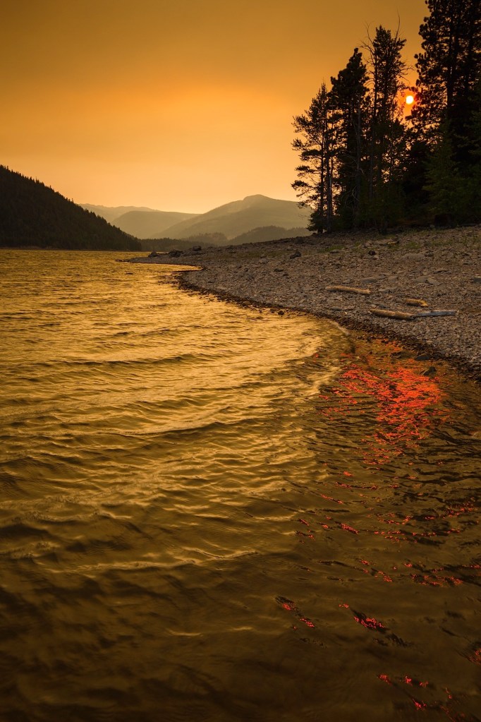 An eerie sunset over Rimrock Lake near Mount Rainier casts yellow and red from the nearby forest fires