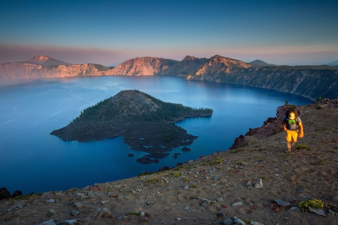 A man hiking the rim at sunset in Crater Lake National Park
