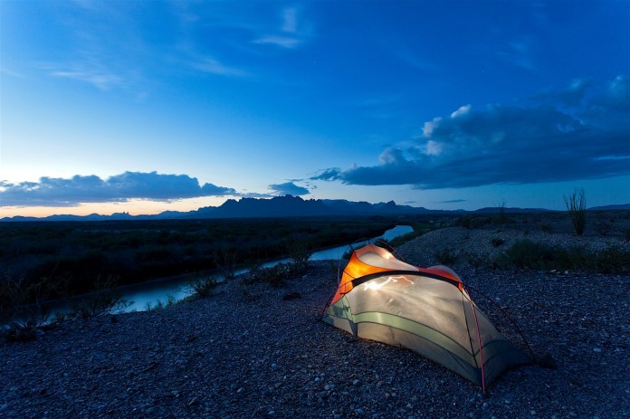 tent camping at dusk on the rio grande and the chisos mountains in big bend national park, texas