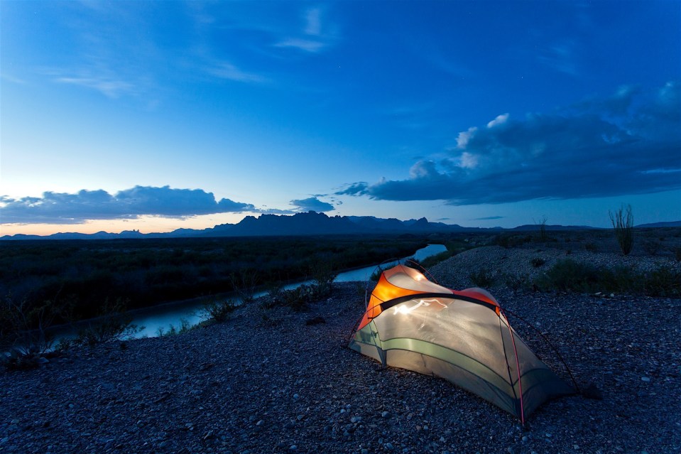 tent camping at dusk on the rio grande and the chisos mountains in big bend national park, texas
