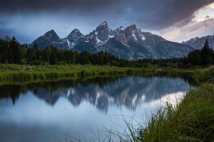 Dramatic clouds loom over Swabachwers Landing in Grand Teton National Park